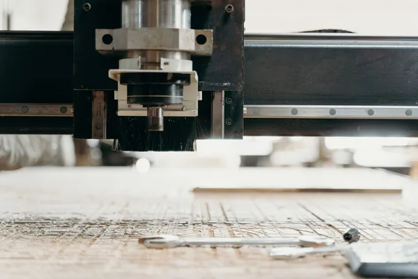 The spindle and gantry of a CNC router above its work table