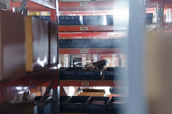Warehouse shelving with small parts bins sorted under location labels