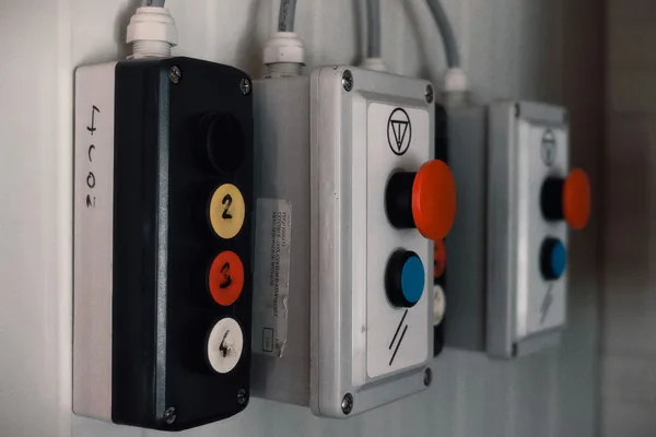 Wall-mounted pushbutton stations with numbered, stop and start buttons