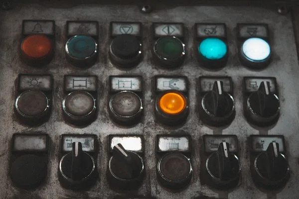 A worn machine operator panel with pilot lights, pushbuttons and selector switches