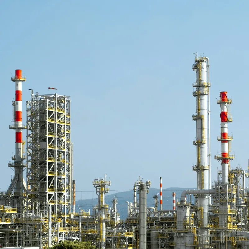 Refinery towers and stacks against a blue sky