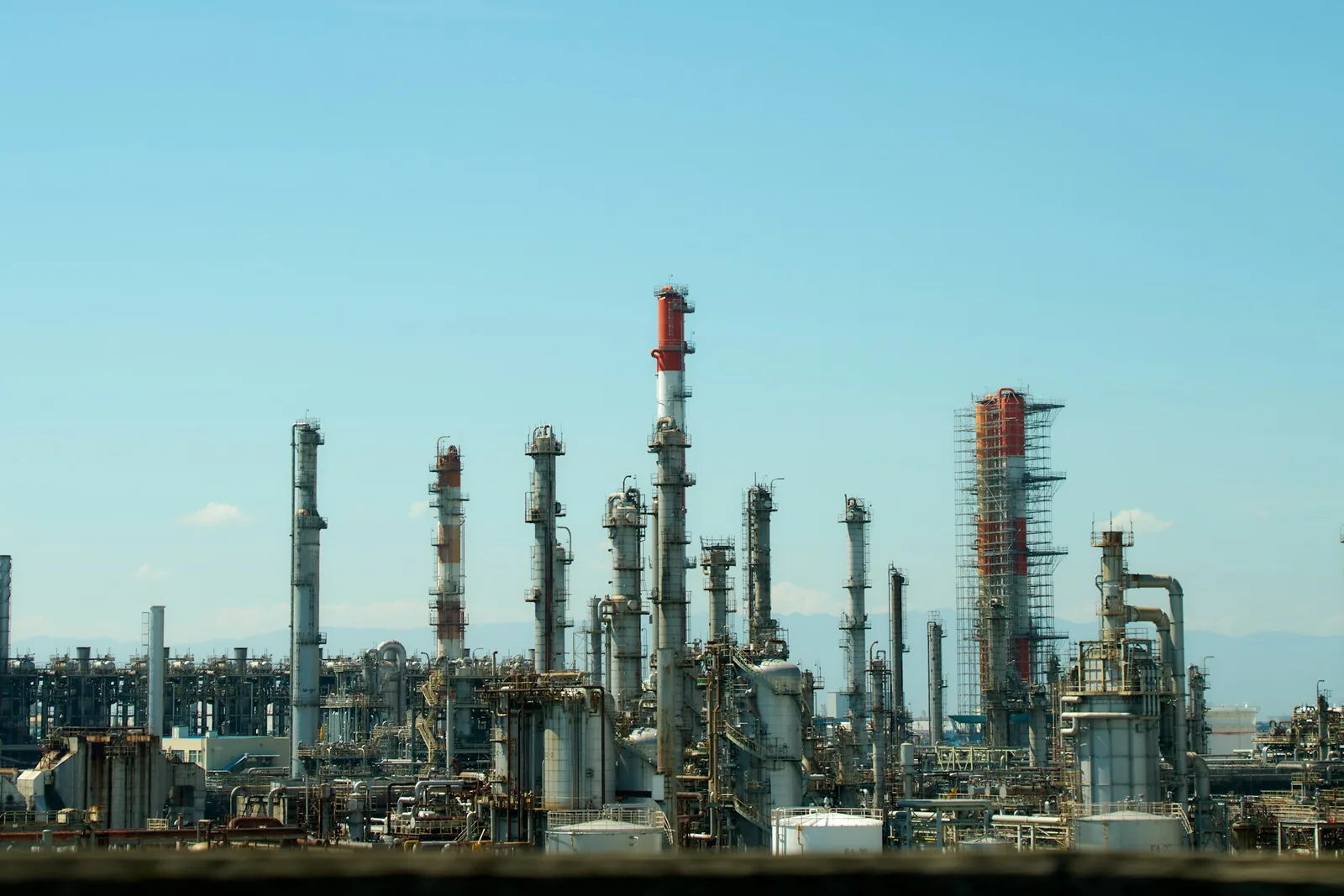 Oil refinery towers and process units under a clear sky